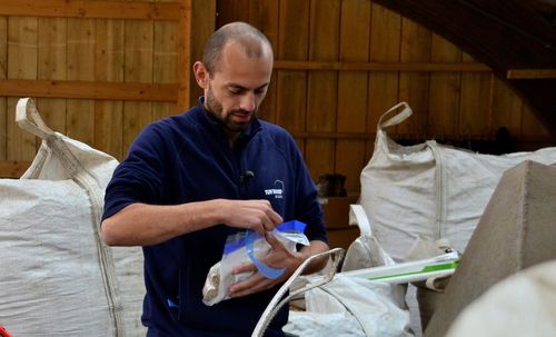 Een controleur checkt de kwaliteit van het voeder voor de varkens  - (c) VLAM, P. De Laet
